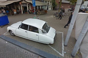 Auto op parkeerplaats op stoep