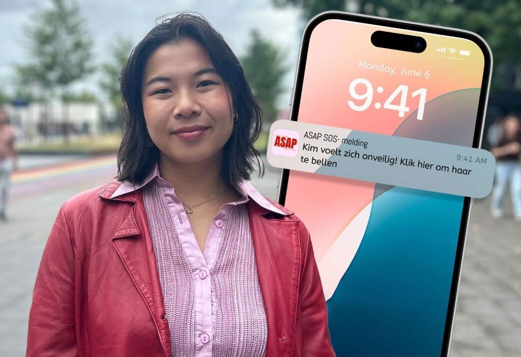 Yeline Hoogmans staat ergens op straat met achter haar een mobiele telefoon die erin is geshopt met een voorbeeld hoe de app ASAP werkt.As Soon As Possisble ASAP.jpg