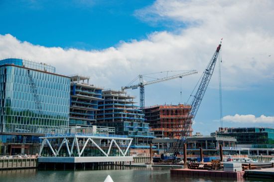 Gebouwen in aanbouw aan het water met hijskranen in Amsterdam